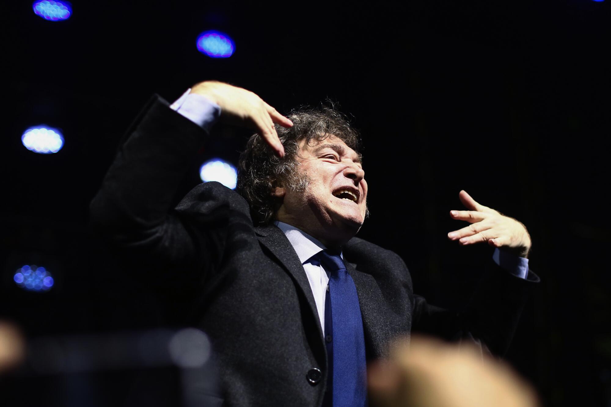 Argentina's President Javier Milei holds his hands up after giving a speech at CPAC Brasil 2024