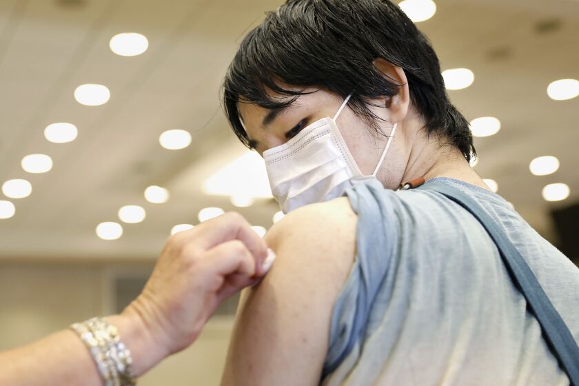 TORRANCE-CA-JULY 7, 2021: Student Sora Fukaya, 22, looks on while receiving a Pfizer vaccination shot at El Camino College in Torrance on Wednesday, July 7, 2021 as the college hosts a one-day COVID-19 vaccination clinic on campus, run by Providence, open to the public for individuals aged 12 and up. (Christina House / Los Angeles Times)