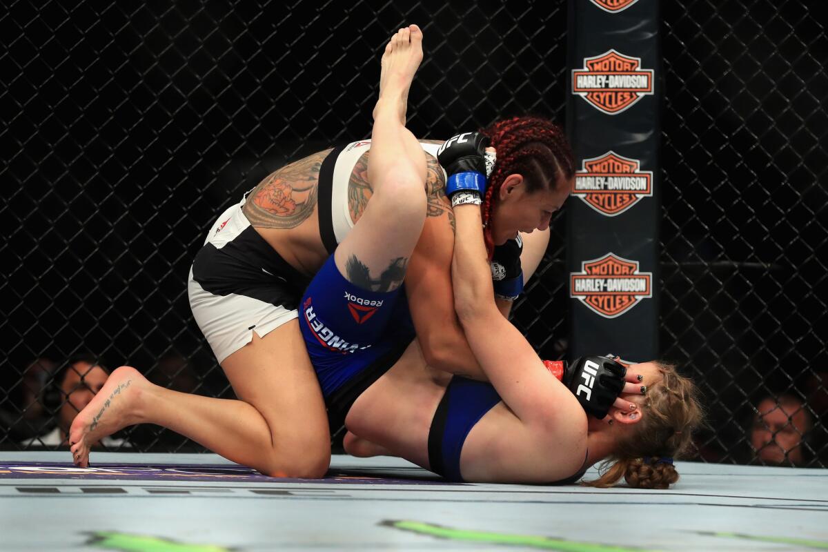 Cris "Cyborg" Justino (top) grapples with Tonya Evinger during their featherweight title fight at UFC 214.