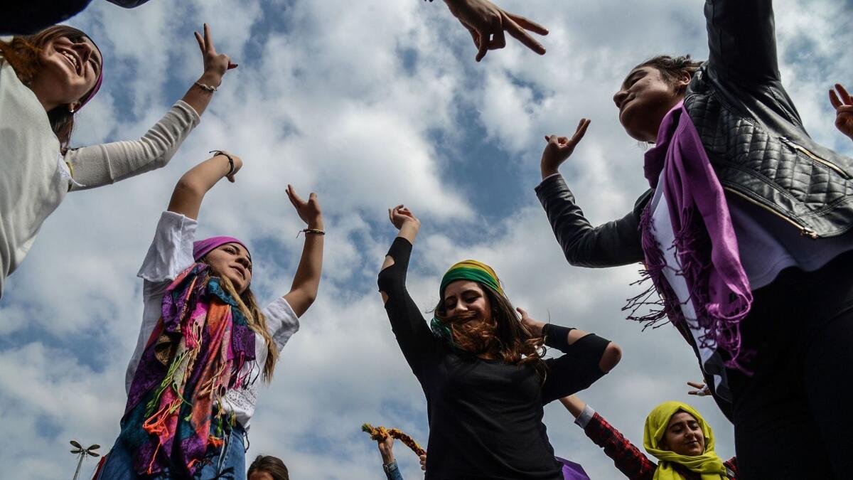 Diyarbakir, Turkey: Women flash victory signs during a demonstration as part of International Women's Day.