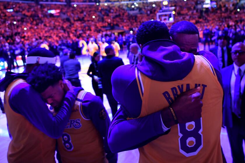 LOS ANGELES, CALIFORNIA JANUARY 31, 2020-Lakers LeBron James, right, hugs Anthony Davis and Quin Cook, second form left, hugs Kentavious Caldwell-Pope after a ceremony honoring Kobe Bryant at the Staples Center Thursday. (Wally Skalij/Los Angeles Times)