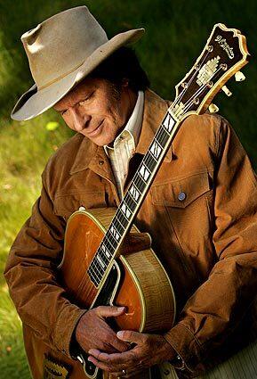 John Fogerty holds his 1945 D'Angelico New Yorker guitar, a love that was fanned in his teens by Chet Atkins' playing.