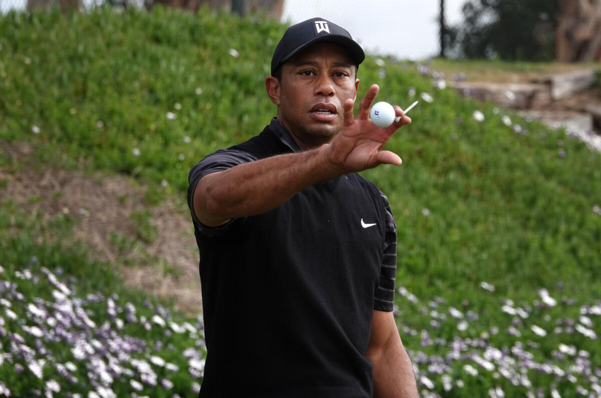 Tigers Woods hit balls on the range at the Torrey Pines Golf Course on Tuesday.