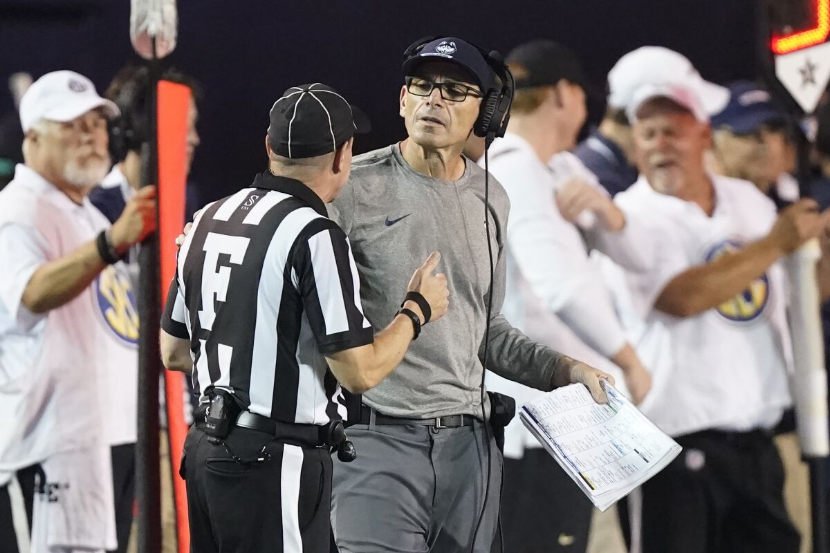 Connecticut head coach Lou Spanos talks to field judge Jay Brown in the first half of an NCAA college football game between Connecticut and Vanderbilt Saturday, Oct. 2, 2021, in Nashville, Tenn. (AP Photo/Mark Humphrey)