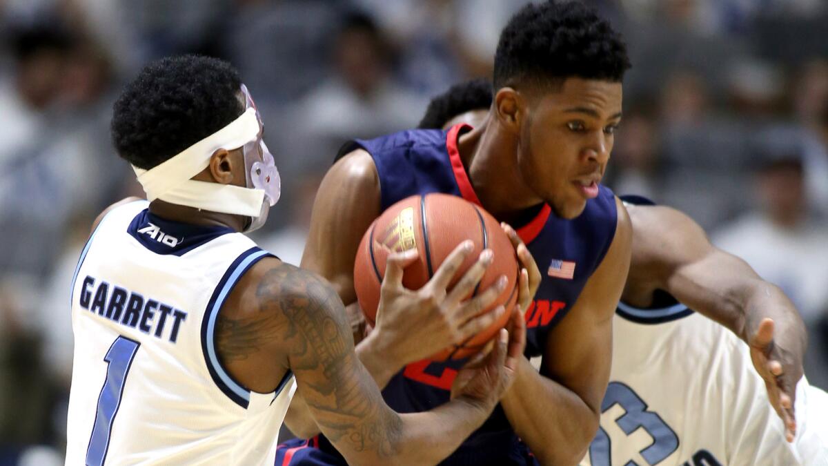 Rhode Island's Jarvis Garrett, left, steals the ball as Dayton's Xeyrius Williams tries to drive between Garrett and teammate Kuran Iverson during the first half Friday.
