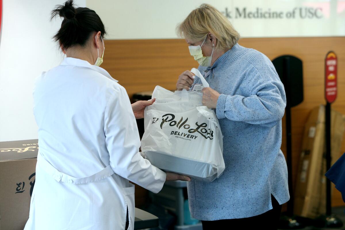 Verdugo Hills Hospital employees pick up lunch delivered from El Pollo Loco, at the hospital lobby in Glendale on Tuesday, April 7, 2020.