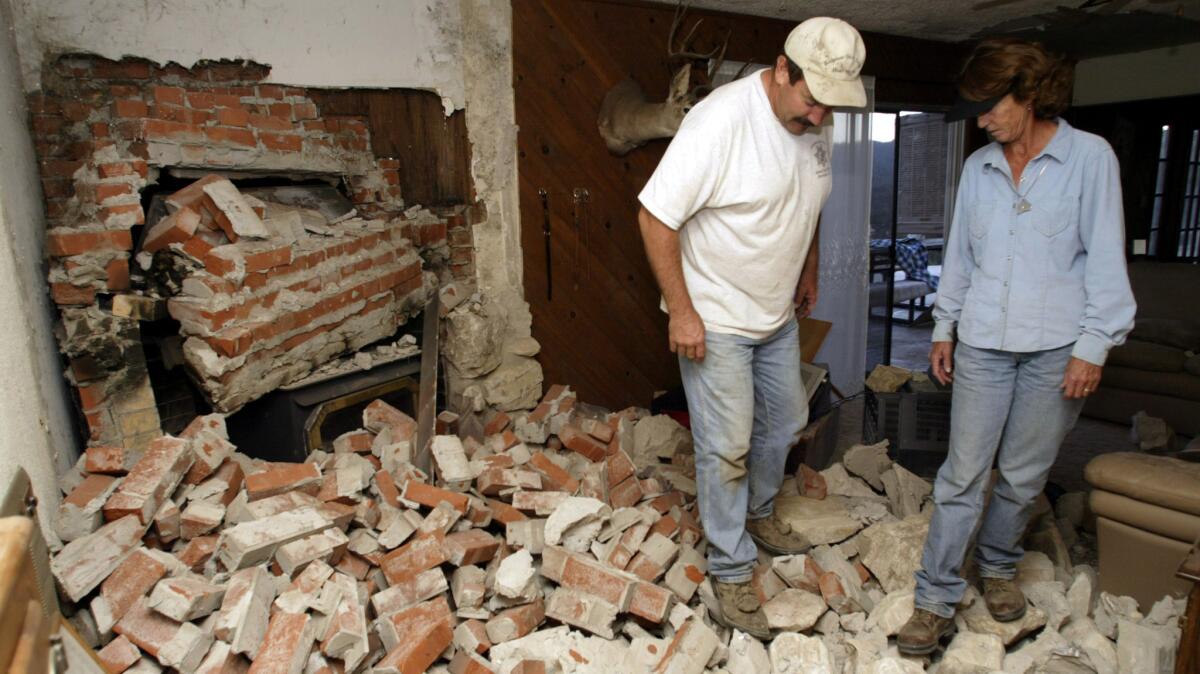Jim and Laurie Batson survey the damage to their Parkfield, Calif., home in 2004. The Batsons had lived in the home, 400 yards from the San Andreas Fault, for 15 years and had not suffered damage in earlier quakes. (Stephen Osman / Los Angeles Times)