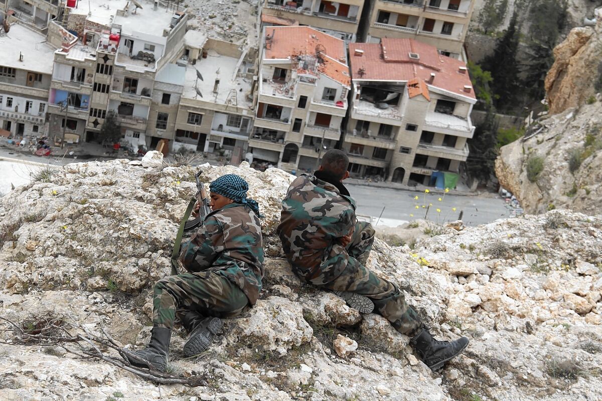 Fighters scan the streets below for any sign of rebels in Maaloula, Syria, where units of the Syrian army, pro-government militiamen and a loyalist Shiite militia have taken over.
