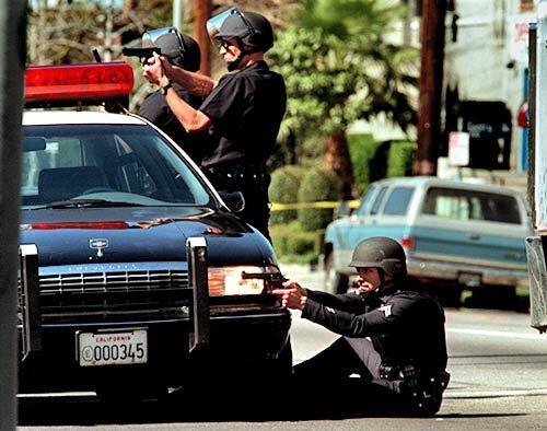 LAPD officers take shooting positions near the corner of Vanowen Street and Gentry Avenue on Feb. 28, 1997. Two suspects were killed while 10 officers and four bystanders were wounded.