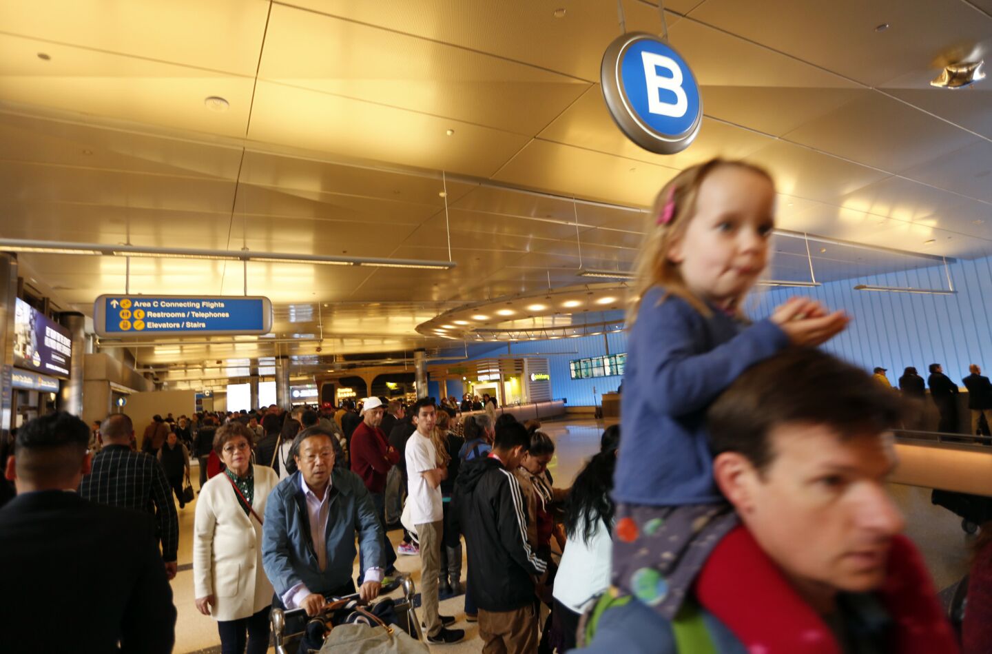 Travelers make their way through a crowded Tom Bradley International Terminal at LAX on Thursday.