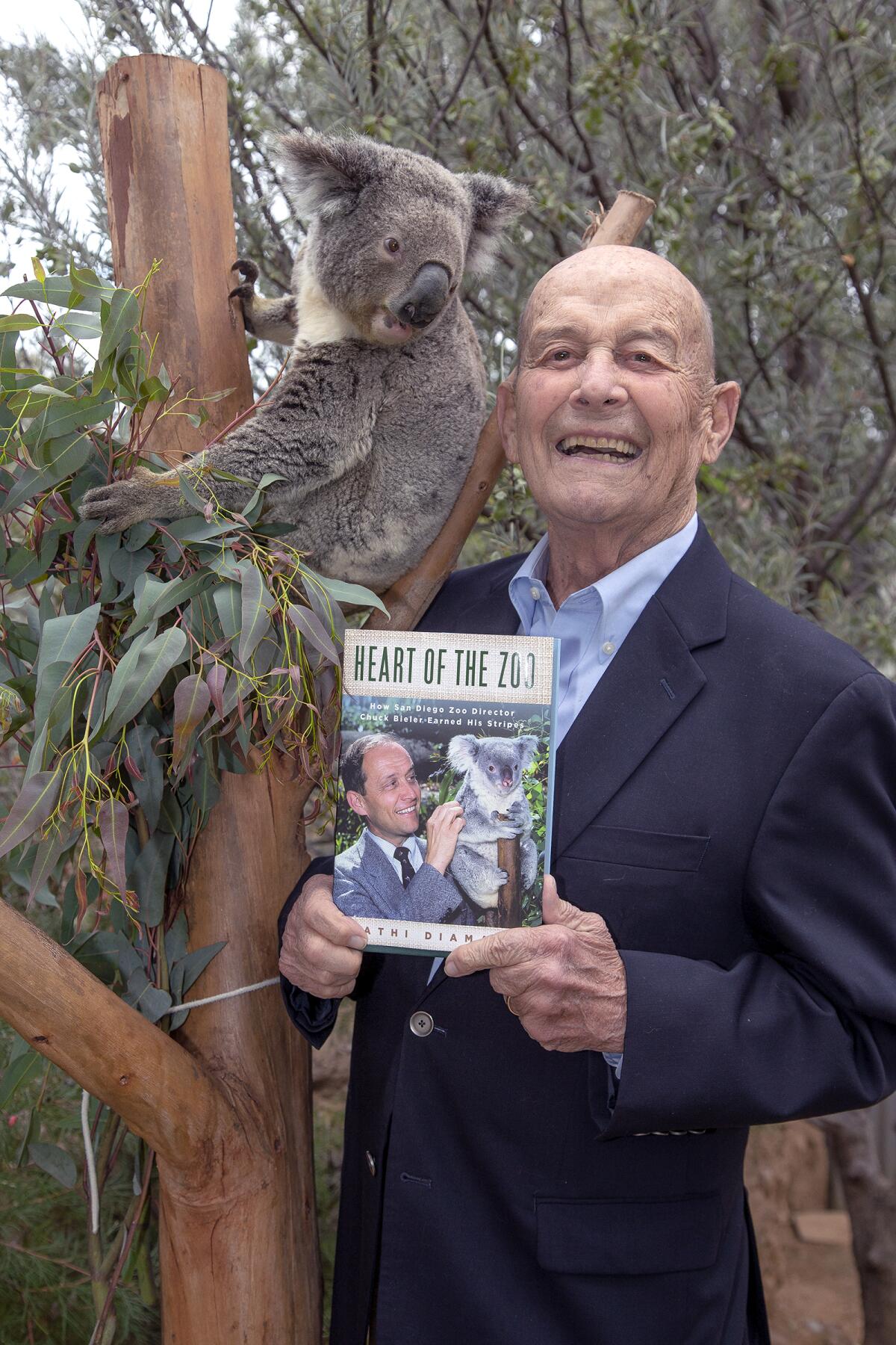 Chuck Bieler holds a book that highlights his contributions to the San Diego Zoo. 