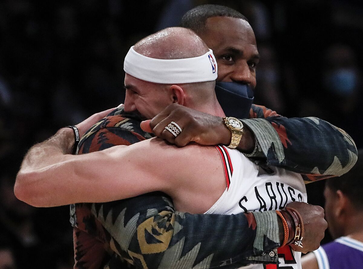 Chicago Bulls guard Alex Caruso hugs LeBron James during a break in the first quarter.