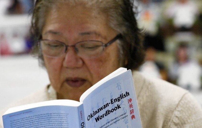 Student Dina Yogi refers to an Okinawan-English dictionary during a class in the Uchinaaguchi language in Gardena. Yogi is of Okinawan descent and is rediscovering her roots through her ancestral language. Many of the students remember their parents or grandparents using the language.