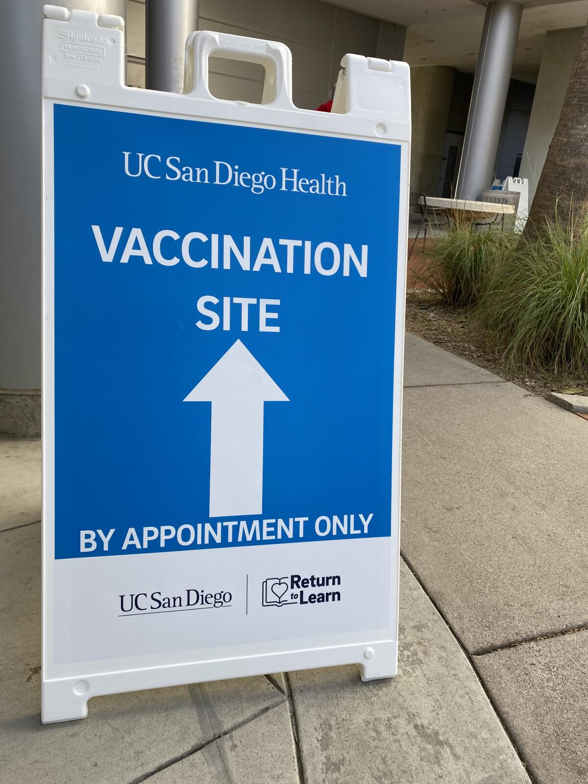 A sign directs people to UC San Diego's new COVID-19 vaccination superstation at the RIMAC arena on campus.