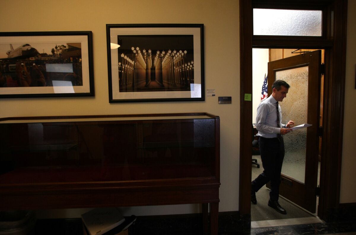 L.A. Mayor Eric Garcetti walks out of his office after meeting with constituents to hear their concerns on his first day in office at City Hall.