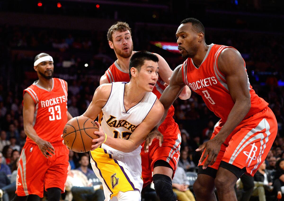 Lakers point guard Jeremy Lin looks to pass after getting trapped by Rockets forwards Joey Dorsey and Donatas Montiejunas on Jan. 25.