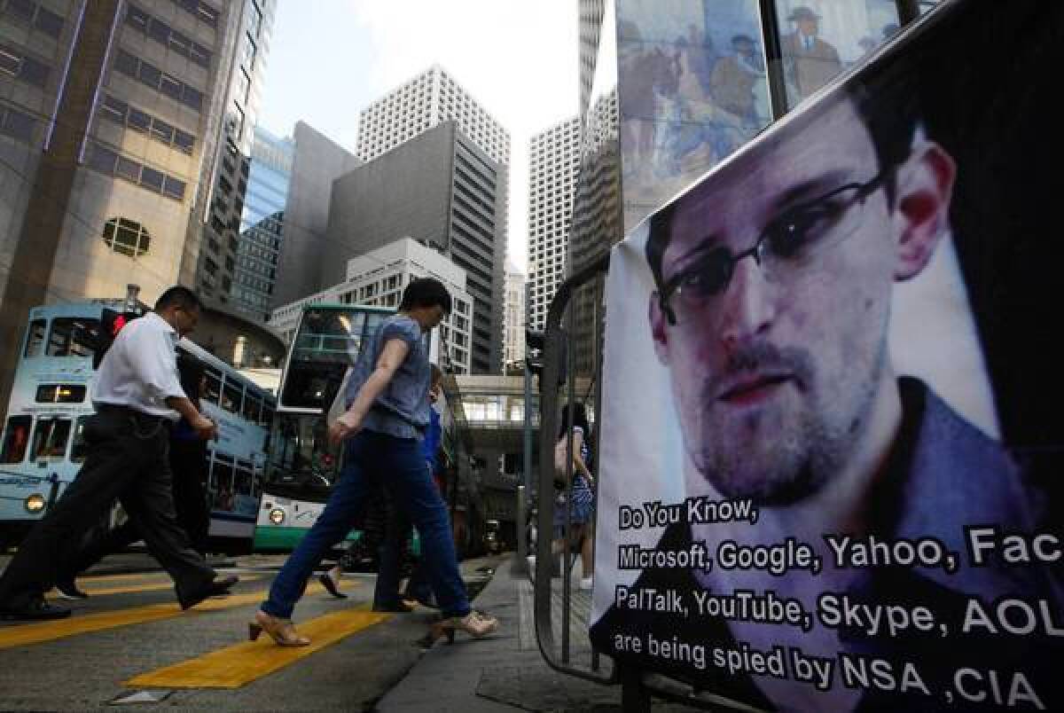 In Hong Kong, pedestrians pass a banner expressing support for Edward Snowden, the former U.S. government contractor who leaked information about surveillance programs. Snowden has been hiding in the Chinese territory.