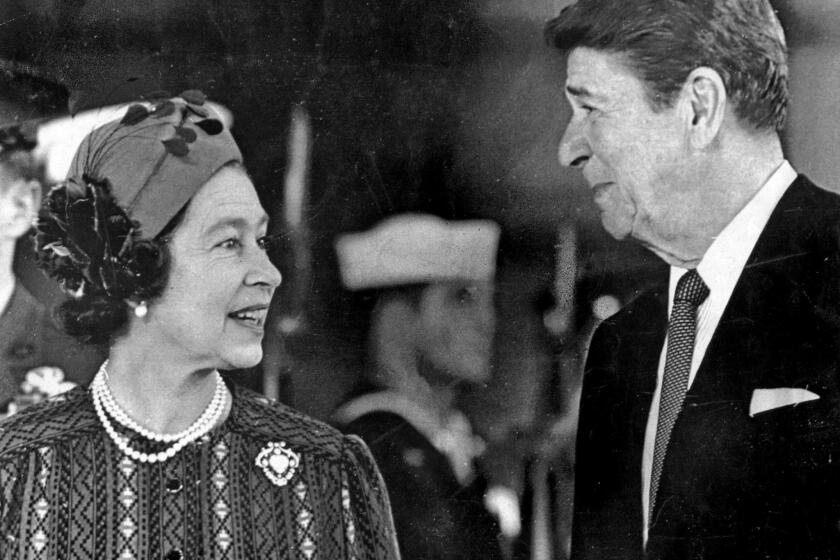 March 1, 1983: Queen Elizabeth II and President Ronald Reagan chat at Santa Barbara airport before a visit to the Reagans' hilltop ranch. This photo was published in the March 2, 1983, Los Angeles Times. (George Rose / Los Angeles Times)