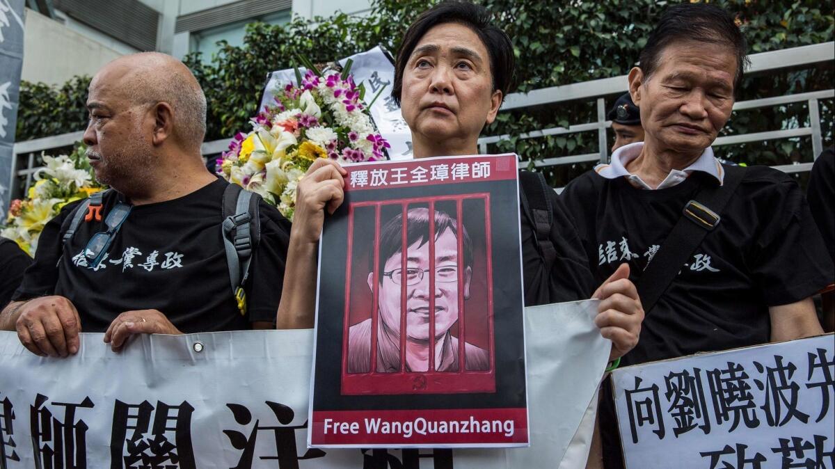 Former Hong Kong lawmaker Emily Lau, center, holds a picture of detained Chinese human rights lawyer Wang Quanzhang at a rally on April 5, 2018.