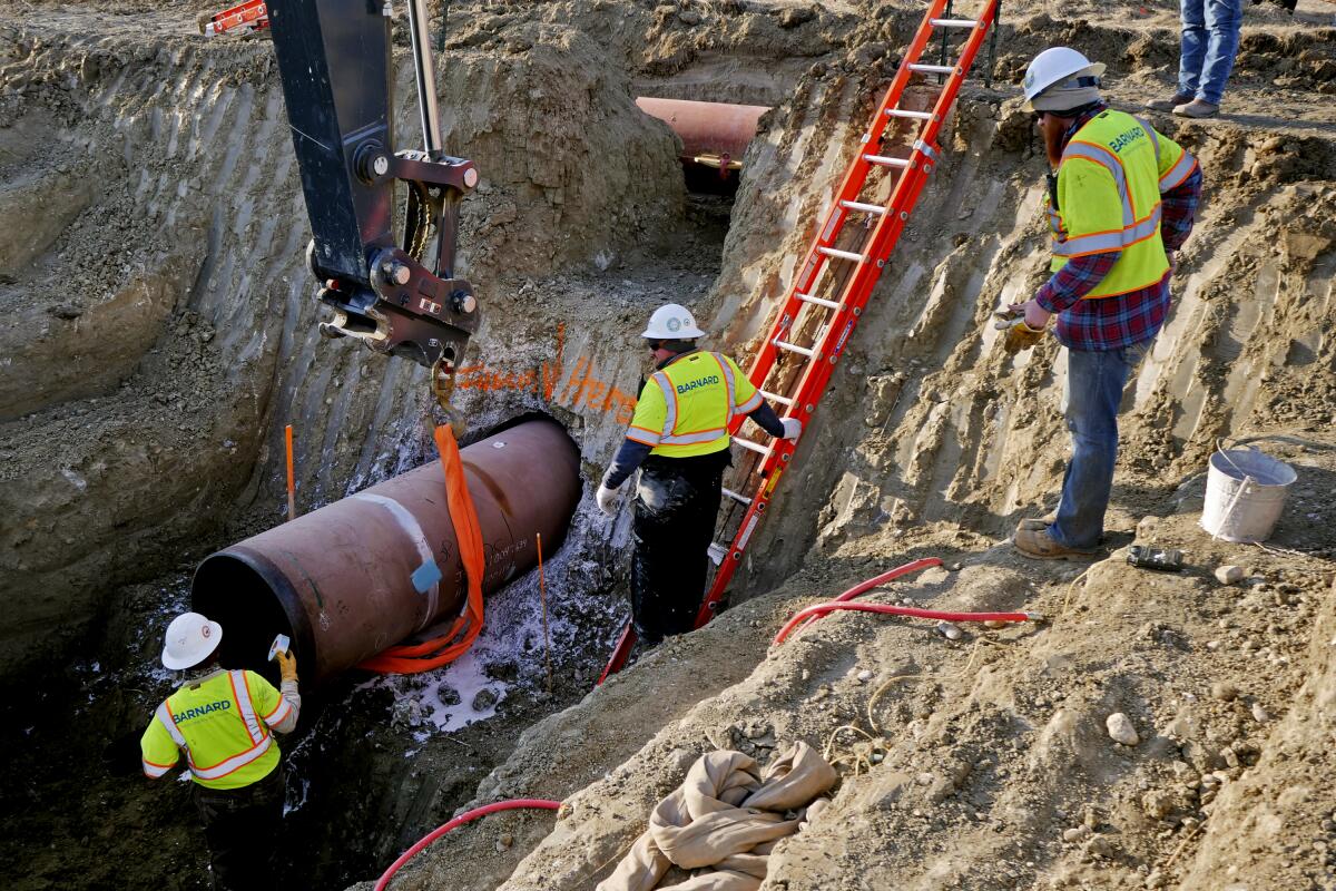 Workers build a section of the Keystone XL pipeline