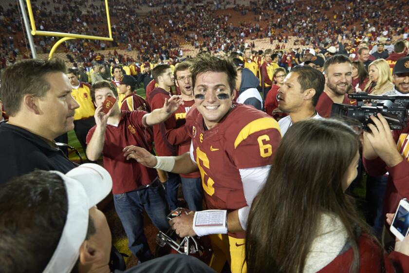 USC quarterback Cody Kessler celebrates with fans at the Coliseum after the Trojans' victory over Stanford on Nov. 16, 2013.