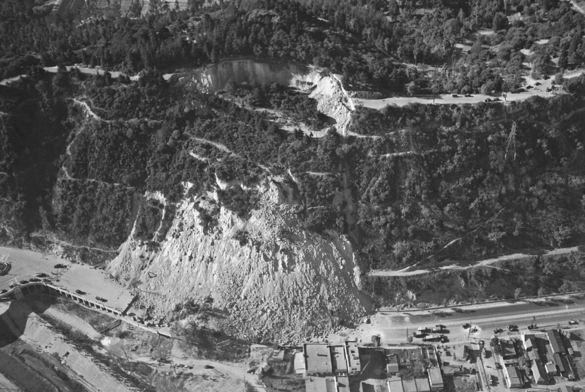 A partial collapse of a cliff is seen from afar.