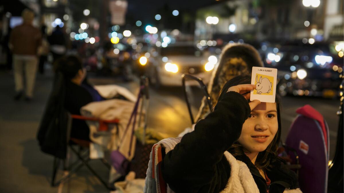 Hailey Cox, 10, plays a game with her grandmother, Linda Betts, not pictured, as they settle in for the evening on Colorado Boulevard.
