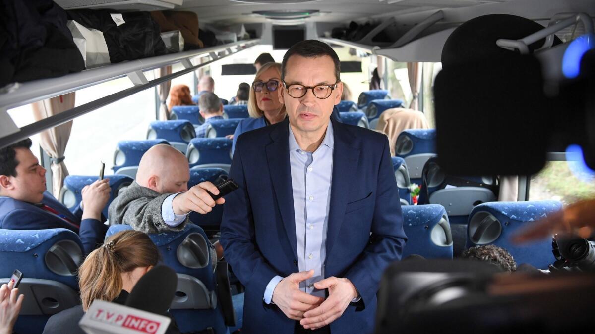 Polish Prime Minister Mateusz Morawiecki speaks to journalists on a bus before leaving Warsaw on Feb. 18.