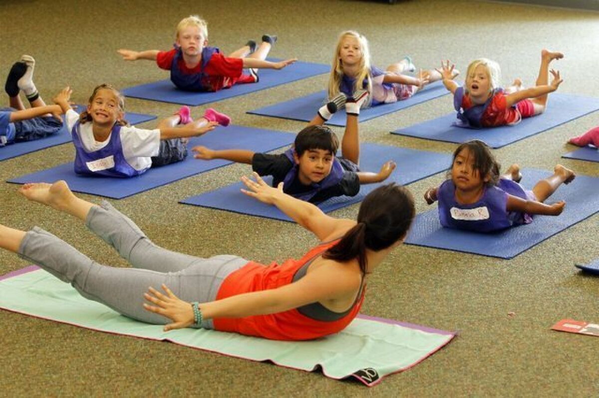 Yoga instructor Jackie Bergenon leads students at Paul Ecke Central Elementary School in Encinitas in a yoga exercise.