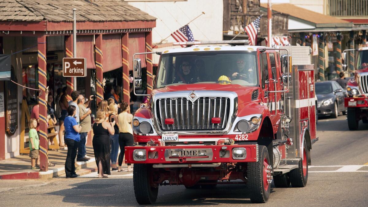 A fire truck, part of a procession carrying the body of firefighter Braden Varney, makes its way along Highway 140 in Mariposa.