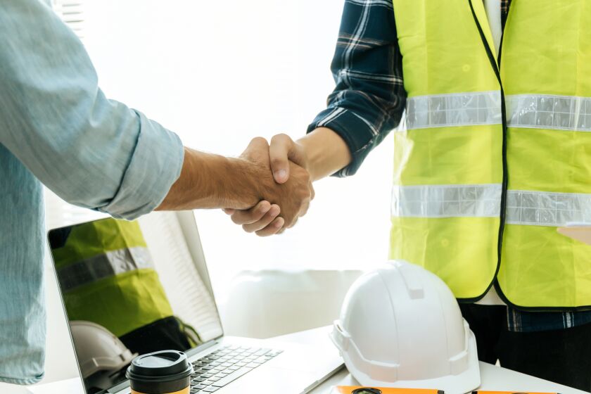 Construction worker team shaking hands.