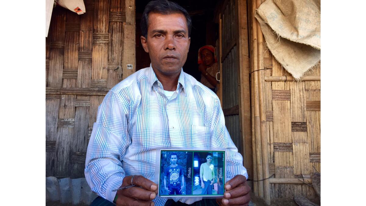 Shafiq Ahmed, 43, in front of his hut in Thet Kae Pyin camp, Myanmar, holds a picture of his sons. The family was chased out of its hometown by Buddhist mobs and government forces.