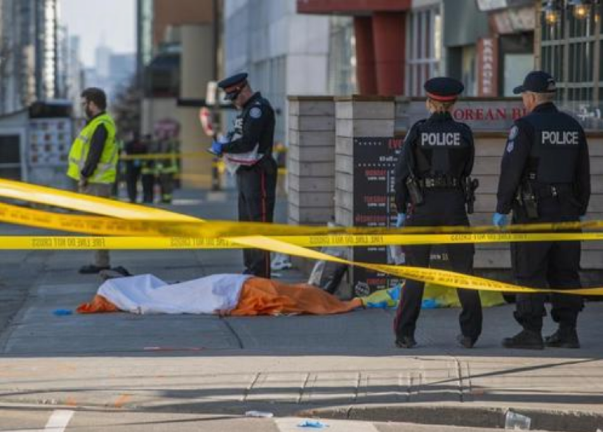 Oficiales de la policía de Toronto vigilan frente a un cuerpo cubierto el lunes 23 de abril de 2018, luego de que una camioneta atropellara a varios peatones en Yonge Street, norte de Toronto (Canadá). EFE/Warren Toda/Archivo