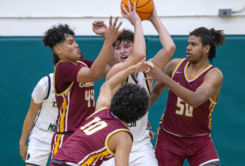 Costa Mesa's Riley Weinstein is guarded by Estancia's Peter Sanchez, left, James De La O, center, and Lewis Tate.