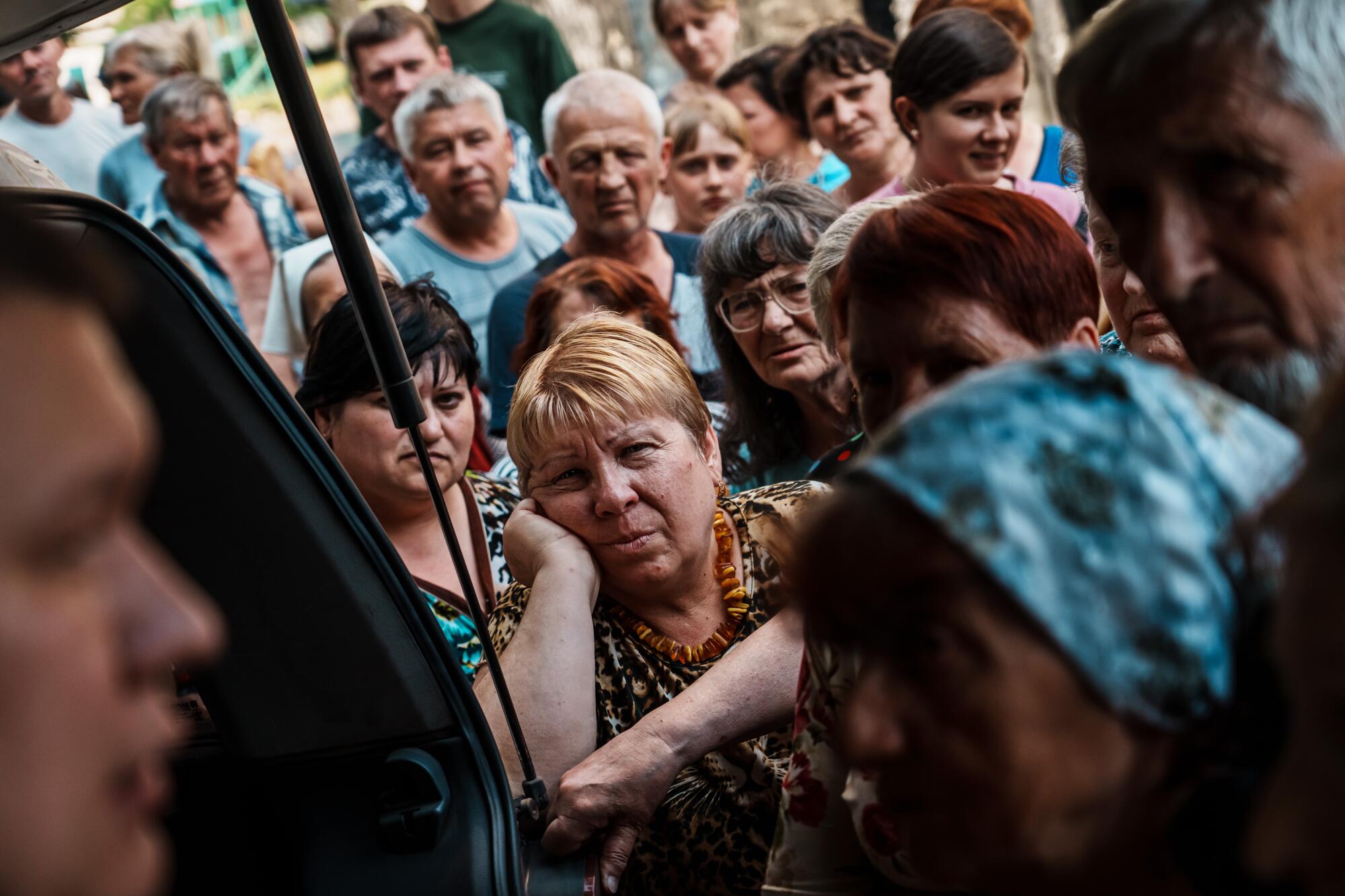 Residents in a residential compound wait for supplies to be given out in Lysychansk, Ukraine