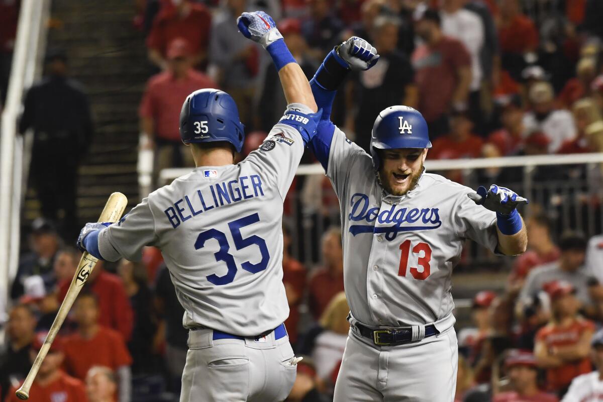 Los Angeles Dodgers Max Muncy (13) celebrates his solo home run off Washington Nationals starting pitcher Anibal Sanchez with Cody Bellinger (35) during the fifth inning in Game 3 of a baseball National League Division Series on Sunday, Oct. 6, 2019, in Washington. (AP Photo/Susan Walsh)