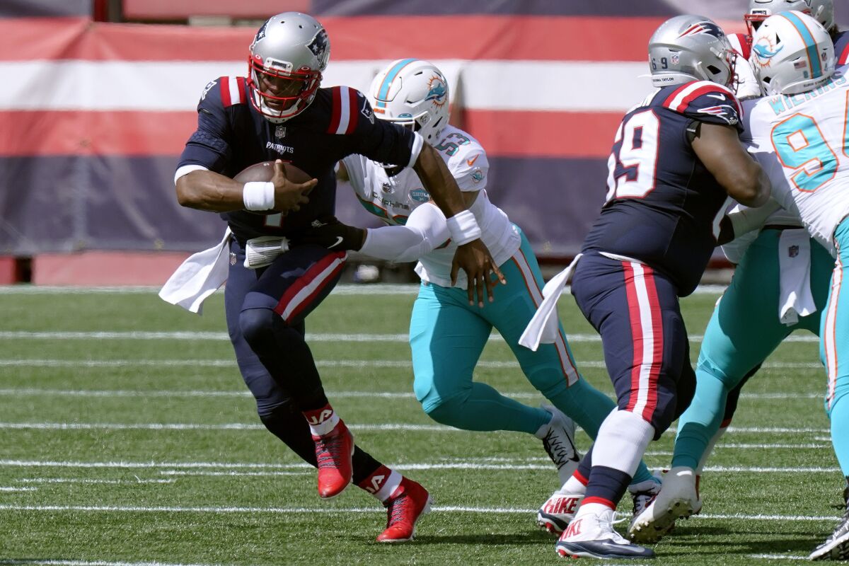 New England Patriots quarterback Cam Newton, front, runs from Miami Dolphins linebacker Kyle Van Noy (53)in the first half of an NFL football game, Sunday, Sept. 13, 2020, in Foxborough, Mass. (AP Photo/Steven Senne)