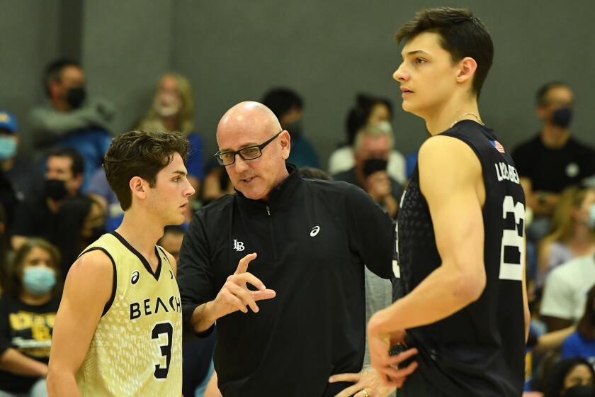 Long Beach State coach Alan Knipe, center, speaks with libero Mason Briggs, left, and outside hitter Alex Nikolov.