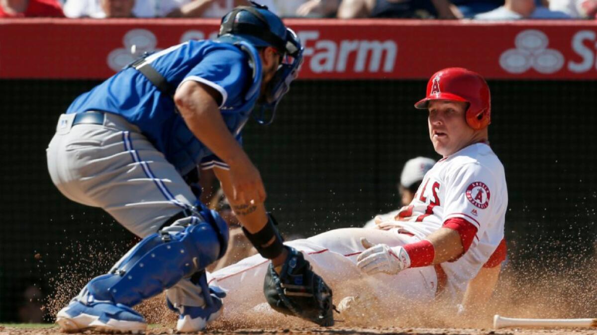 Angels outfielder Mike Trout scores ahead of a tag by Toronto Blue Jays catcher Dioner Navarro in the fifth inning.