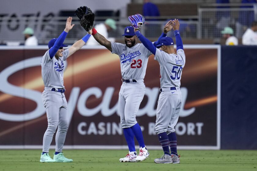 De izquierda a derecha, el boricua Kiké Hernández, Jason Heyward y Mookie Betts festejan el triunfo de los Dodgers de Los Ángeles, el viernes 4 de agosto de 2023 (AP Foto/Gregory Bull)