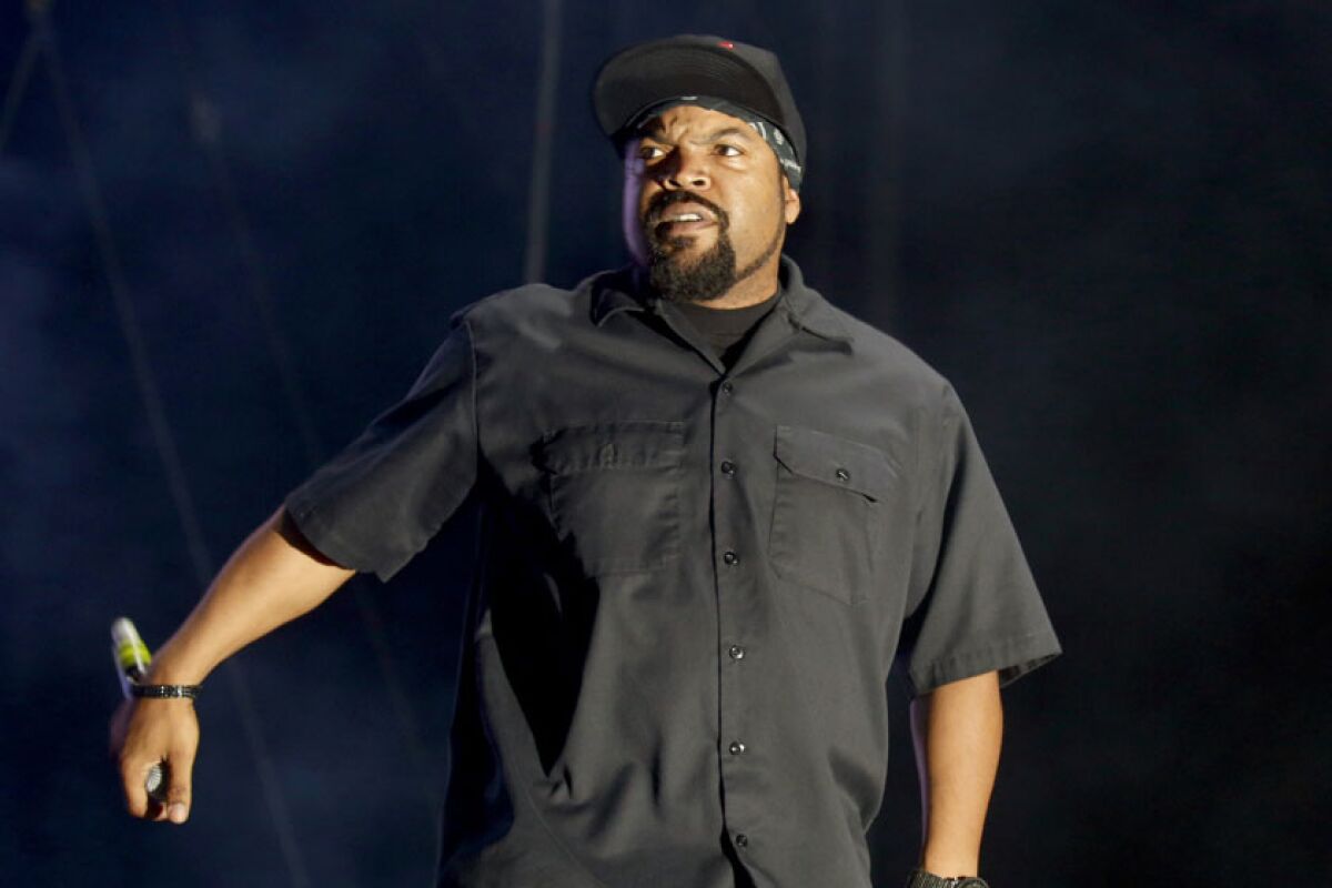 Ice Cube wearing a black shirt and black hat.