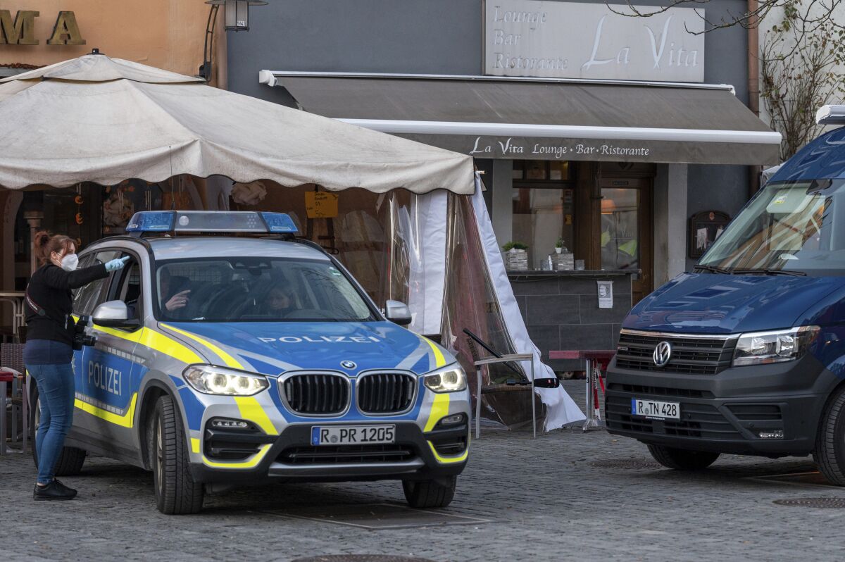 Police vehicles are stand in front of a restaurant in the city of Weiden, Germany, Sunday, Feb. 13, 2022. One man died and eight others were hospitalized in serious condition after drinking spiked drinks at a bar in the Bavarian city. (Photo: Armin Weigel/dpa via AP)