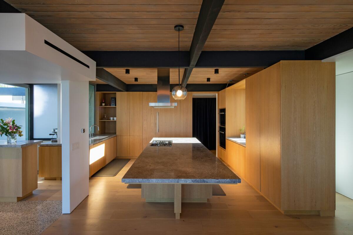 A modern kitchen with white oak cabinets and a large island.
