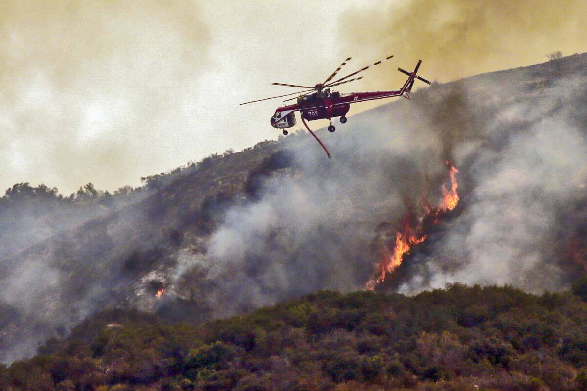 Los Angeles County Fire Department helicopters drop water on the Fish fire in Duarte on Wednesday.