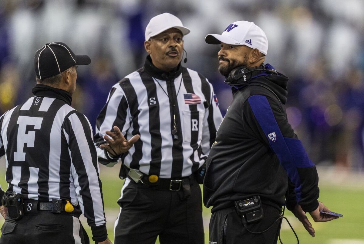 Washington head coach Jimmy Lake, right, reacts while talking with field judge Jeffrey Yock, left, and referee Michael Mothershed, center, during the first half of an NCAA college football game against Oregon, Saturday, Nov. 6, 2021, in Seattle. (AP Photo/Stephen Brashear)