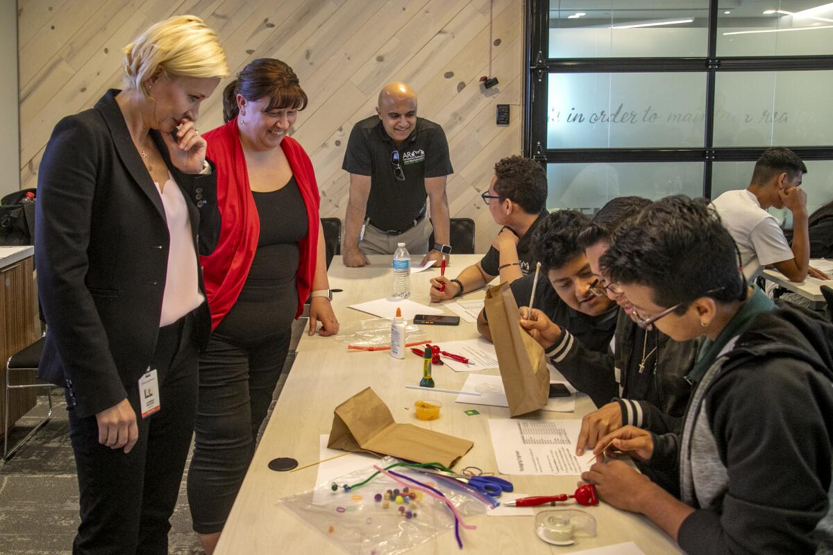 Biosense Webster President Jasmina Brooks and Stacey Darling look over students' projects during a campus tour on Thursday.