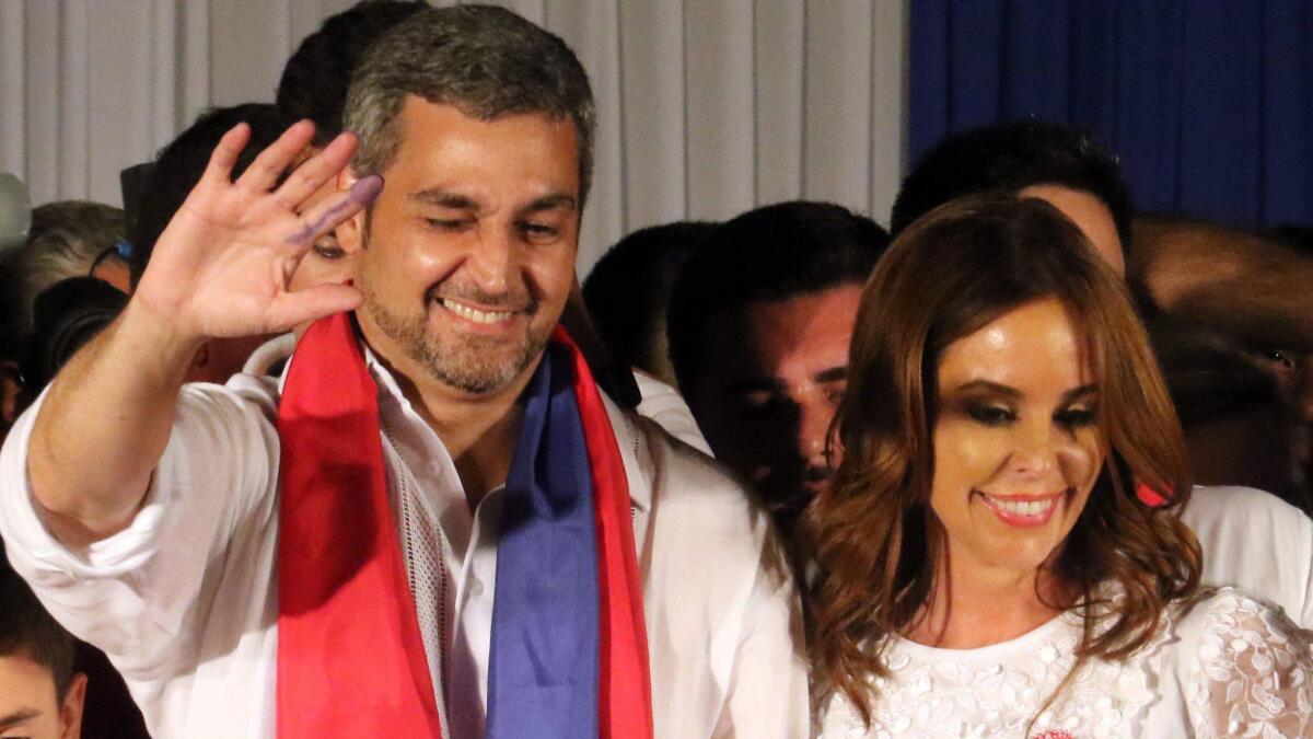 Mario Abdo Benitez reacts to his supporters, accompanied by his wife Silvana Lopez in front of the headquarters of the Colorado Party in Asuncion, Paraguay, on April 22.