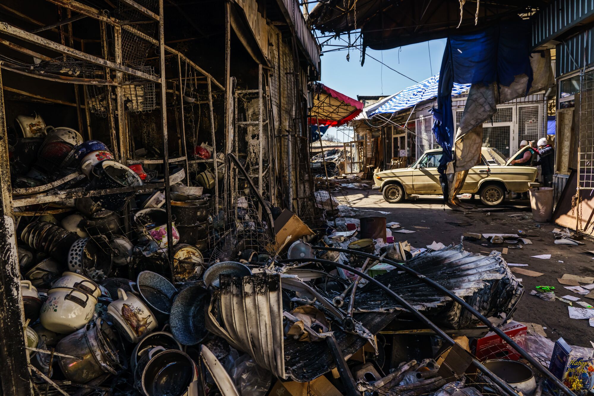 People collect what's left of shops burned down in the Barabashova market in Kharkiv, Ukraine.