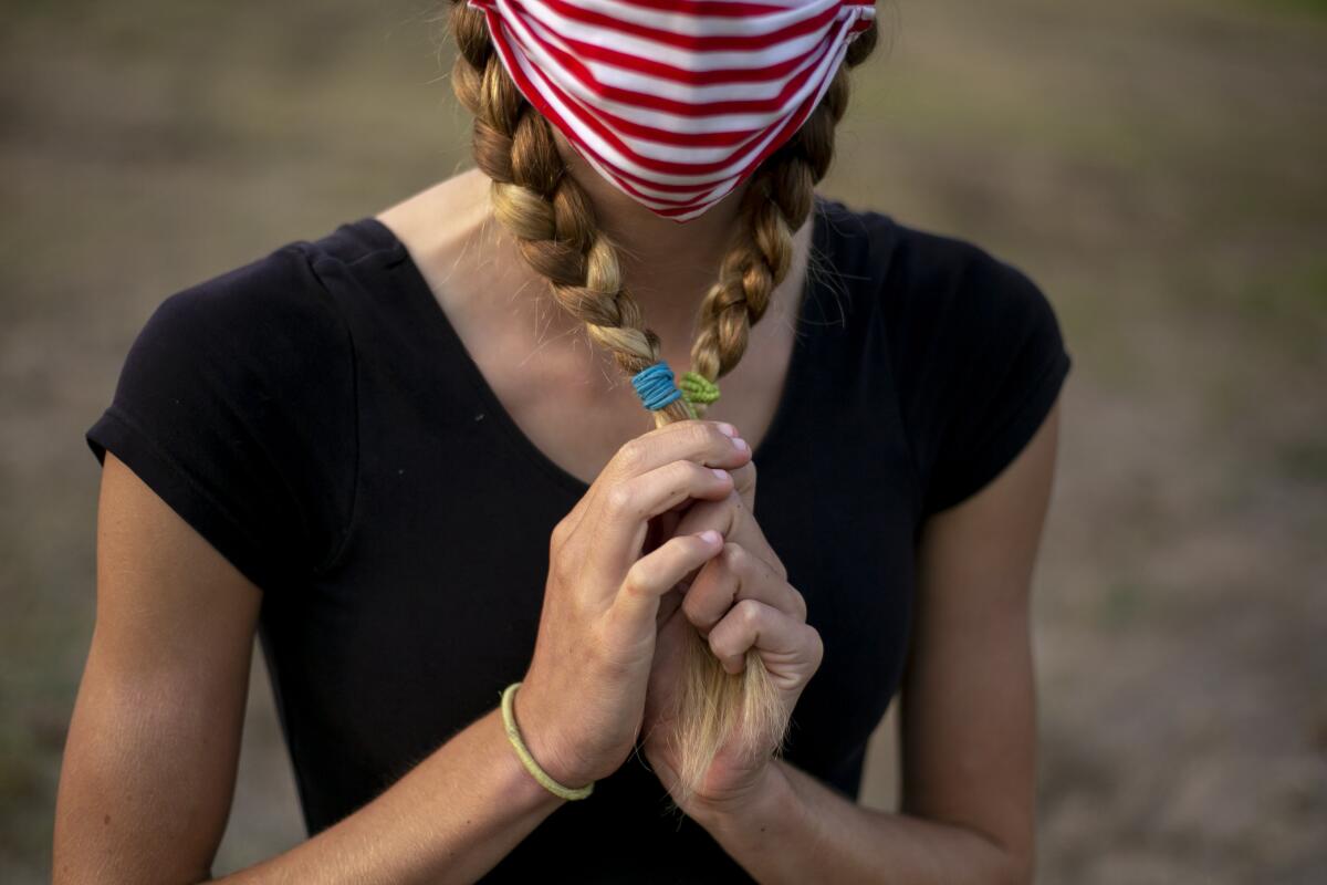 Brinkley Baker, 15, holds her braids at Kenneth Hahn Park in Los Angeles.  Sept. 9, 2020.