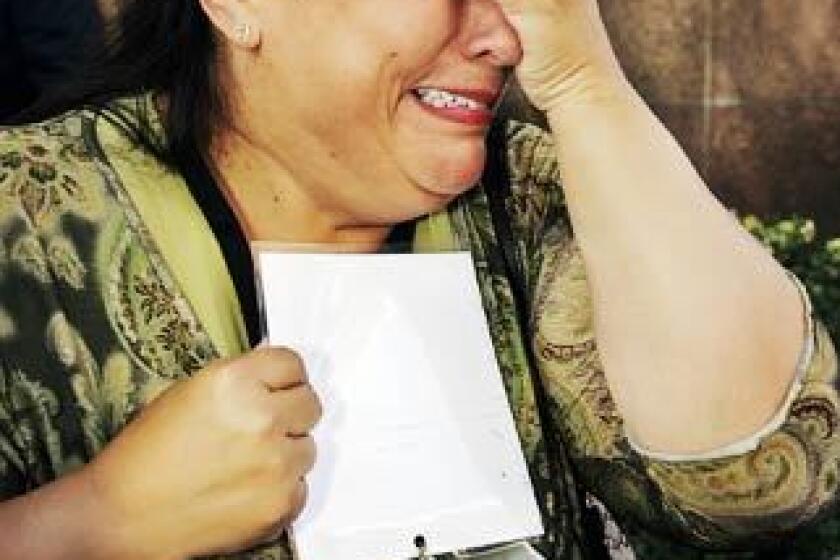 Plaintiff Esther Miller weeps while talking to the media outside Los Angeles County Superior Court. She holds a photo of Michael Nocita, the former priest she says abused her when she was a teenager in Van Nuys.